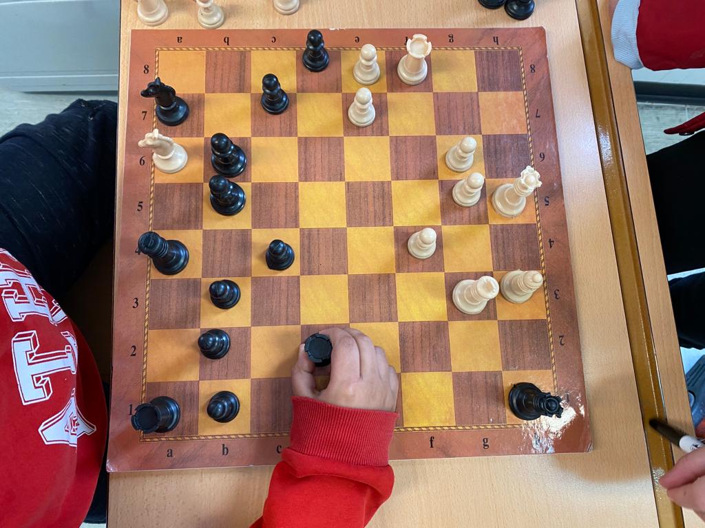Vista cenital de un tablero de ajedrez con alumnado jugando
