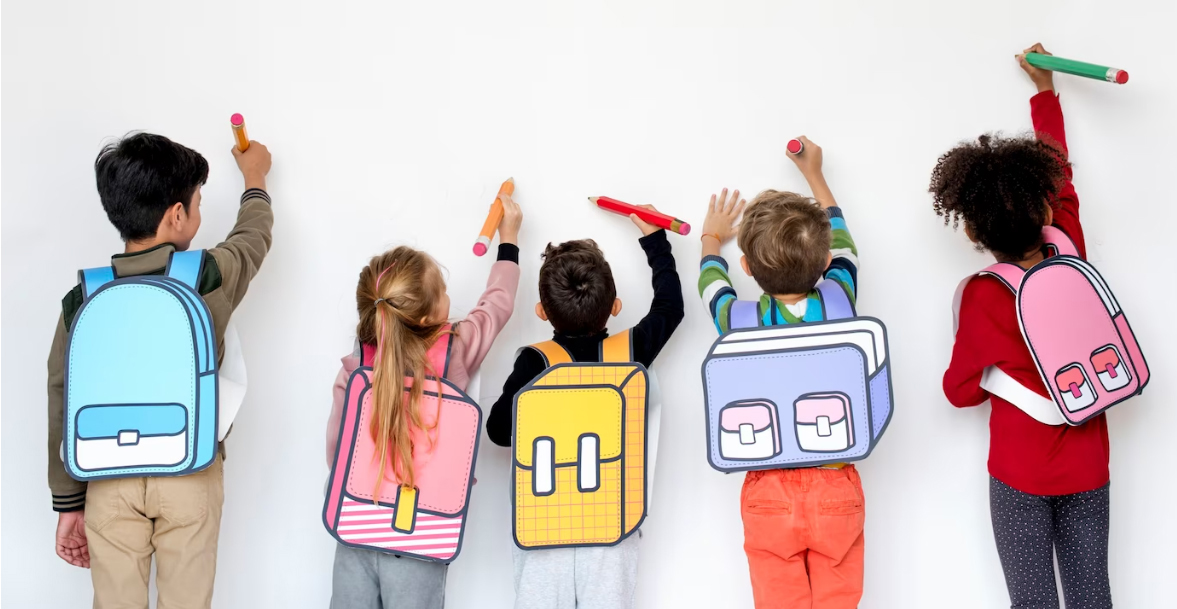 Niñas y niños dibujando con grandes lápices de colores en una actividad de ADSE
